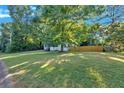 Well-maintained front yard featuring lush green grass and mature trees providing ample shade at 54 Mildred Ct, Dallas, GA 30157