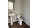 Half bathroom featuring hardwood floors and a pedestal sink at 6446 Grey Fox Way, Riverdale, GA 30296