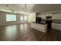Open concept living area featuring wood floors, a kitchen island, and natural light at 6446 Grey Fox Way, Riverdale, GA 30296