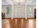 Sunlit foyer with hardwood floors and white trim, showcasing the home's classic architectural details at 3499 Paces Ferry Se Cir, Smyrna, GA 30080