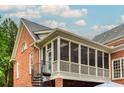Exterior view of a brick house with a screened porch and spiral staircase at 3499 Paces Ferry Se Cir, Smyrna, GA 30080