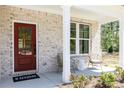 Inviting front porch featuring stylish chairs, a side table, and a vibrant red front door at 608 Belshire Dr, Acworth, GA 30102