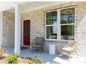 Welcoming front porch showcasing comfortable seating, elegant columns, and a striking red door at 608 Belshire Dr, Acworth, GA 30102