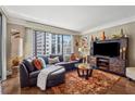 Comfortable living room with city views from the large windows and a plush leather sofa at 3481 Lakeside Ne Dr # 1103, Atlanta, GA 30326