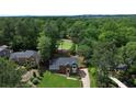 Expansive aerial view of the home showcasing mature trees and a well-maintained lawn, highlighting the neighborhood at 10310 Amberside Ct, Roswell, GA 30076