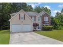 Inviting two-story home with a two-car garage, brick facade, and well-maintained landscaping at 6032 Trotters Cir, Fairburn, GA 30213
