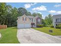 Attractive two-story home with a double garage, vinyl siding, brick accents, and a manicured front lawn at 6032 Trotters Cir, Fairburn, GA 30213