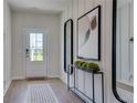 Welcoming entryway featuring modern decor, light wood flooring, and natural light streaming through the front door at 146 Kingsley Way, Acworth, GA 30102