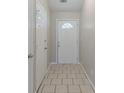 Bright entryway with light tile flooring and a white front door with a decorative window at 8350 Gledstone Way, Fairburn, GA 30213