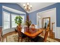 Dining room with bay windows, wood table set, and view of the front hallway at 3480 Arbroath Dr, Douglasville, GA 30135