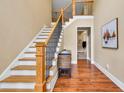 Inviting foyer with wooden staircase, hardwood floors, and decorative wrought iron railings at 3865 Pointer Rd, Loganville, GA 30052