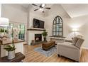 Cozy living room with a fireplace, hardwood floors, vaulted ceiling, and plenty of natural light at 504 River Run Dr, Atlanta, GA 30350