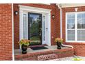 Close up of the beautiful home entrance, brick facade, black door, white door frame, and flower pots at 535 Sugar Gate Ct, Lawrenceville, GA 30044