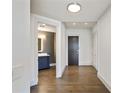 Hallway featuring modern lighting, wood floors, leading to a bathroom with stylish vanity at 3107 Peachtree Ne Rd # 1005, Atlanta, GA 30305