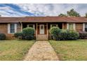 Charming single story home featuring a stone walkway, mature trees, and a covered front porch at 5687 Highway 212, Covington, GA 30016