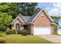 Charming brick home showcasing a well-manicured lawn and a two-car garage at 1026 Lester Se Ave, Atlanta, GA 30316