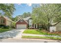 Charming two-story brick home with an attached garage, lush green lawn, and mature shade trees at 425 Fieldstone Lndg, Alpharetta, GA 30005