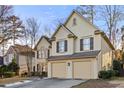 Side view of a tan two-story home with a two car garage and manicured yard at 5105 Riverthur Pl, Duluth, GA 30096
