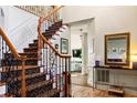 Elegant foyer showcasing a staircase with wood and wrought iron banister and tiled floors at 5105 Riverthur Pl, Duluth, GA 30096
