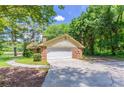 View of the home's brick garage and paved driveway surrounded by lush greenery at 1296 Carman Se Ct, Conyers, GA 30013