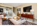 Open living space with a rustic coffee table, flat screen TV, and mirrored wall reflecting the outdoors at 145 15Th Ne St # 1225, Atlanta, GA 30309