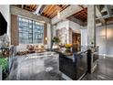Spacious loft living room featuring concrete floors, exposed brick and ductwork, and large industrial windows at 650 Glen Iris Drive Ne # 27, Atlanta, GA 30308