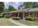 Lovely brick home featuring a manicured lawn, sidewalk, and a welcoming front porch at 1890 Silvastone Dr, Decatur, GA 30033