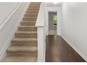 A carpeted staircase adjoins a hardwood floor hallway and landing at 6750 Blackstone Pl # 6, Mableton, GA 30126