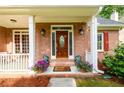 Welcoming front porch with brick facade, decorative plants, and stylish front door at 2430 Harbin Springs Cv, Dacula, GA 30019
