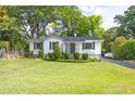 Charming exterior of home with white brick, dark shutters, front porch, and landscaped front yard at 1039 Ridgecrest Se Dr, Smyrna, GA 30080