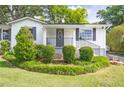 Well maintained front yard featuring landscaped bushes, green grass, and dark shutters on the windows at 1039 Ridgecrest Se Dr, Smyrna, GA 30080