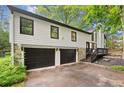 Two-car garage with stone accent and updated exterior; inviting curb appeal at 104 River Creek Dr, Woodstock, GA 30188
