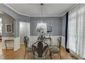 Elegant dining room featuring hardwood floors, a decorative chandelier, and large window with natural light at 1045 Legacy Walk, Woodstock, GA 30189