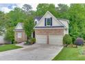 Charming home with stone facade, attached two-car garage, and well-manicured lawn at 1045 Legacy Walk, Woodstock, GA 30189