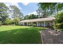 Ranch home with a sprawling front yard, manicured landscaping and covered front porch at 515 Houze Way, Roswell, GA 30076