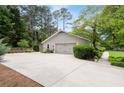 Spacious two-car garage with extra parking space and lush landscaping at 515 Houze Way, Roswell, GA 30076