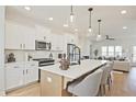 Modern kitchen with island, stainless appliances, pendant lights, and a view to the living room at 1923 Deco Dr, Kennesaw, GA 30144