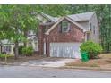 Inviting two-story home with a brick facade, attached garage, and landscaped front yard at 7078 Ravenwood Ln, Lithonia, GA 30038