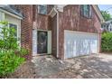 Close-up of the brick facade, front door, and attached two-car garage at 7078 Ravenwood Ln, Lithonia, GA 30038