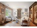 Bright and airy living room featuring a brick accent wall and an elegant display cabinet at 114 Karland Nw Dr, Atlanta, GA 30305