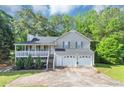 Charming home featuring a covered porch, two car garage and mature trees at 185 Wyngate Ct, Dallas, GA 30157
