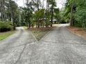 Long driveway of brick home splits to left and right with trees, shrubs, and grass in the background at 1935 Lamp Post Ln, Lawrenceville, GA 30043