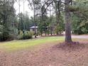 Brick home with a nicely manicured front yard, mature trees, shrubs and grass at 1935 Lamp Post Ln, Lawrenceville, GA 30043
