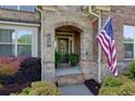 Inviting front porch with stone accents and American flag at 225 Sundance Dr, Woodstock, GA 30188