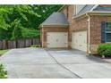Spacious two-car garage with neutral doors, side yard, and a wide driveway at 225 Sundance Dr, Woodstock, GA 30188