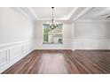 Elegant dining room featuring tray ceiling, wainscoting and wood flooring at 2889 Windsor Knoll Dr, Dacula, GA 30019