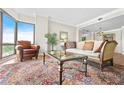 Bright living room with large windows, hardwood floors, and an ornate oriental rug at 3475 Oak Valley Ne Rd # 950, Atlanta, GA 30326