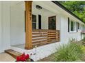 Close up of updated white brick home with natural wood porch and trim at 1477 Spruce Se Dr, Smyrna, GA 30080