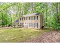 Traditional two-story home with black shutters and a well-manicured lawn surrounded by mature trees at 205 N Fayette Dr, Fayetteville, GA 30214