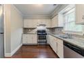 Kitchen featuring white cabinets, stainless steel appliances, and granite countertops at 205 N Fayette Dr, Fayetteville, GA 30214